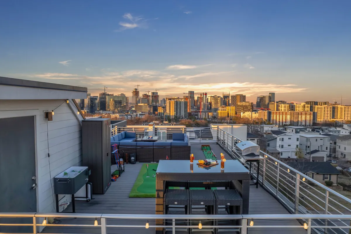 The hero image showcases a stunning rooftop terrace overlooking the Nashville city skyline, featuring a spacious dining table, a putting green for fun, and ample seating for socializing or enjoying sunset views. The setup invites guests to dine al fresco, host barbecues, play mini-golf, and take in panoramic city vistas—ideal for special moments like fireworks displays.
