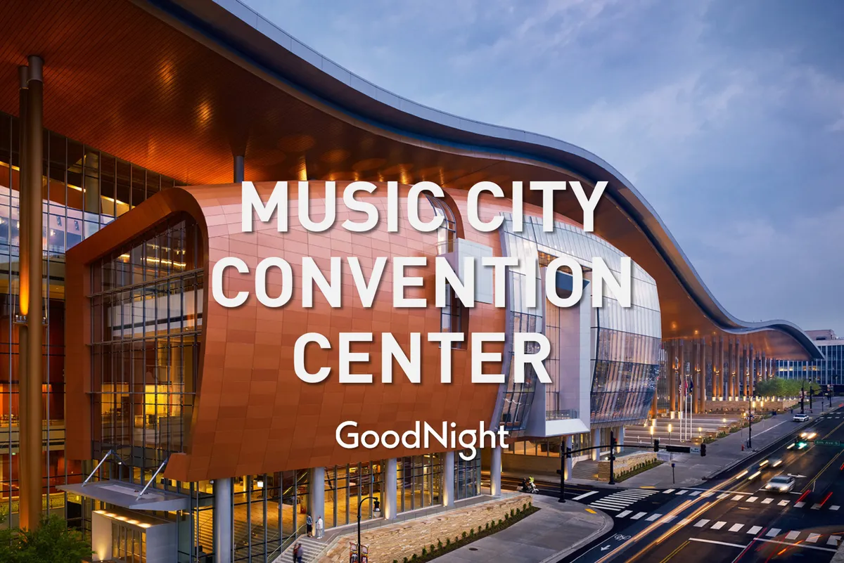 The striking exterior of the Music City Center, Nashville’s renowned conference and event venue, with its curved glass architecture and energetic atmosphere. The facade is welcoming, hinting at the proximity to major business events and cultural gatherings.